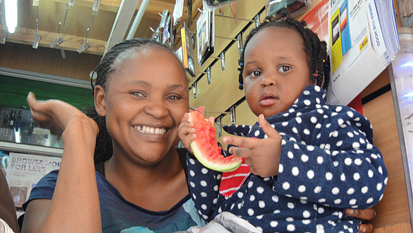 Nairobilainen kännykkäkaupan myyjä tyttärensä kanssa.